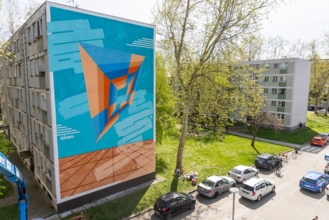 Zgrada s plavo-narančastim muralom na bočnom zidu.